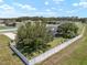 Aerial view of a spacious backyard enclosed by a white fence with mature trees providing ample shade at 3612 Se 47Th Ter, Ocala, FL 34480