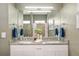 Bathroom with double sinks, granite countertop, ample cabinetry, large mirror and decorative towels and plants at 3612 Se 47Th Ter, Ocala, FL 34480