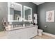 Bathroom featuring dual sinks, granite counters, and illuminated mirrors at 3612 Se 47Th Ter, Ocala, FL 34480