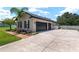 Exterior shot showcasing a three car garage, manicured landscaping, and a concrete driveway at 3612 Se 47Th Ter, Ocala, FL 34480