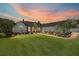 Stunning home exterior with lush lawn, manicured landscaping, and a beautiful sunset backdrop at 3612 Se 47Th Ter, Ocala, FL 34480