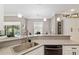 Kitchen featuring a breakfast bar with sink, white cabinets, and stainless steel dishwasher at 3612 Se 47Th Ter, Ocala, FL 34480