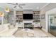 Bright living room showcasing fireplace with shelving, decorative items, television and ceiling fan at 3612 Se 47Th Ter, Ocala, FL 34480