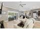 Living room features a ceiling fan, white couches, tile flooring, a fireplace, and sliding glass doors to the backyard at 3612 Se 47Th Ter, Ocala, FL 34480