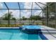 Sparkling screened-in pool and spa with waterfall feature surrounded by lush landscaping, perfect for relaxation and entertaining at 3612 Se 47Th Ter, Ocala, FL 34480