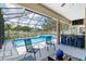 Amazing screened-in pool area features a bar, ample seating, and lush landscaping for a perfect outdoor retreat at 3612 Se 47Th Ter, Ocala, FL 34480