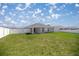 Spacious backyard with a white fence, lush lawn, and covered patio at 4909 Se 89Th St, Ocala, FL 34480