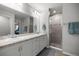 Bright bathroom featuring double sinks, framed mirrors, and walk-in shower with glass door at 4909 Se 89Th St, Ocala, FL 34480