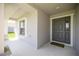 Covered entryway with gray front door and decorative trim, offering a welcoming entrance to the home at 4909 Se 89Th St, Ocala, FL 34480