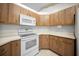 Traditional kitchen with wood cabinets, white appliances, and white countertops at 4992 Nw 31St St, Ocala, FL 34482