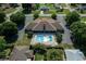 Aerial view of community center with pool, lounge chairs, ample parking, and a manicured lawn, promising leisure at 4992 Nw 31St St, Ocala, FL 34482