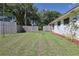 Spacious backyard with green grass, mature trees, and a privacy fence on a sunny day at 5060 Ne 4Th St, Ocala, FL 34470