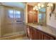 Bathroom featuring a glass shower door, a granite countertop, and a wood vanity with storage at 5060 Ne 4Th St, Ocala, FL 34470
