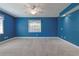Bright primary bedroom features a ceiling fan, carpet flooring and ample natural light at 5060 Ne 4Th St, Ocala, FL 34470