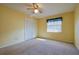 Bright bedroom features neutral carpet, white closet doors, and natural light from the window at 5060 Ne 4Th St, Ocala, FL 34470