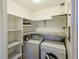 Bright laundry area with shelving, countertop, and full size washer and dryer at 5060 Ne 4Th St, Ocala, FL 34470