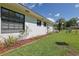 Landscaped yard features lush green grass, mature tropical plants, and the home's exterior at 5060 Ne 4Th St, Ocala, FL 34470