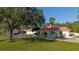 Stately home with a red tile roof, complemented by lush green lawns and mature trees, offering a serene and private ambiance at 6381 Sw 21St Court Rd, Ocala, FL 34471