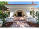Home's front entryway with a unique arched design, tiled steps and manicured landscaping at 6381 Sw 21St Court Rd, Ocala, FL 34471