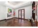 Inviting living room features a fireplace, hardwood floors, and french doors, perfect for relaxing and entertaining at 6381 Sw 21St Court Rd, Ocala, FL 34471