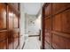 Hallway leading to a powder room with decorative wallpaper and dark wood accents at 6381 Sw 21St Court Rd, Ocala, FL 34471