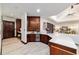 Modern wet bar with wood cabinetry, wine fridge, and decorative tile backsplash at 6381 Sw 21St Court Rd, Ocala, FL 34471