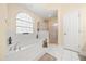 Bright bathroom with a large tub, tiled flooring, and separate shower with gold trim at 645 Sw 48Th Ln, Ocala, FL 34471