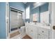 Well-lit bathroom featuring blue wallpaper, a walk-in shower, and a white vanity at 645 Sw 48Th Ln, Ocala, FL 34471