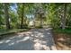 Long driveway leading to a charming home surrounded by lush greenery and mature trees at 645 Sw 48Th Ln, Ocala, FL 34471