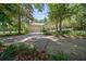Long driveway leading to a home with an attached garage and surrounded by lush greenery at 645 Sw 48Th Ln, Ocala, FL 34471