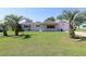 Charming single-story home featuring a well-manicured lawn and mature palm trees in the front yard at 6472 Sw 106Th Pl, Ocala, FL 34476