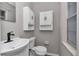 Modern bathroom with white cabinets, sink, toilet and a window offering natural light at 6820 Se 108Th St, Belleview, FL 34420