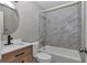 Beautiful bathroom with a modern vanity, shower-tub combo, and decorative tile at 6820 Se 108Th St, Belleview, FL 34420