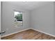 Cozy bedroom featuring light gray walls, wood-look floors, and a bright window at 6820 Se 108Th St, Belleview, FL 34420