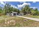 Expansive property featuring a white home, extended driveway, and surrounding wooded area at 6820 Se 108Th St, Belleview, FL 34420