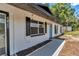 Charming home featuring a white exterior, black shutters, and a bright blue front door at 6820 Se 108Th St, Belleview, FL 34420