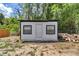 Exterior of a small storage shed with a white door and a stack of firewood nearby at 6820 Se 108Th St, Belleview, FL 34420