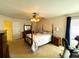 Bright bedroom featuring a four-poster bed, ceiling fan, and plenty of natural light at 7134 Sw 129Th Terrace Road, Ocala, FL 34481