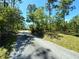 Shady driveway leading through a wooded area with lush green grass at 7134 Sw 129Th Terrace Road, Ocala, FL 34481