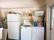 Functional laundry area with washer, dryer, and storage shelves at 7134 Sw 129Th Terrace Road, Ocala, FL 34481