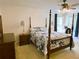 Main bedroom with a four-poster bed, complemented by side tables and natural light; restful retreat at 7134 Sw 129Th Terrace Road, Ocala, FL 34481