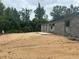 The image shows the cinder block structure under construction, with a concrete slab and surrounded by lush trees at 74 Pine Trace Crse, Ocala, FL 34472