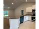 Modern kitchen features white cabinets, stainless steel appliances, and a contrasting turquoise dishwasher at 74 Pine Trace Crse, Ocala, FL 34472