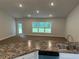 Open concept view from the kitchen into the well-lit living room with a view of the backyard at 74 Pine Trace Crse, Ocala, FL 34472