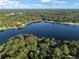 The aerial view showcases a calm lake surrounded by lush greenery and various homesites at 754 Se 167Th Court Rd, Silver Springs, FL 34488