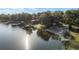 Aerial view of a lakeside property with lush trees, private beach, and a modern home at 754 Se 167Th Court Rd, Silver Springs, FL 34488