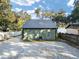 Cozy home features a metal roof and gravel driveway near a tranquil lake, with a fenced yard and lush greenery at 754 Se 167Th Court Rd, Silver Springs, FL 34488