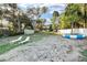 Spacious backyard with a sandy area, mature trees, a trampoline, and lake access, perfect for outdoor activities at 754 Se 167Th Court Rd, Silver Springs, FL 34488