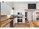 Well-lit kitchen with wood counters, stainless-steel appliances and easy access to bedrooms at 754 Se 167Th Court Rd, Silver Springs, FL 34488