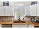 Bright kitchen features white cabinets, wood countertops, and a modern sink at 754 Se 167Th Court Rd, Silver Springs, FL 34488
